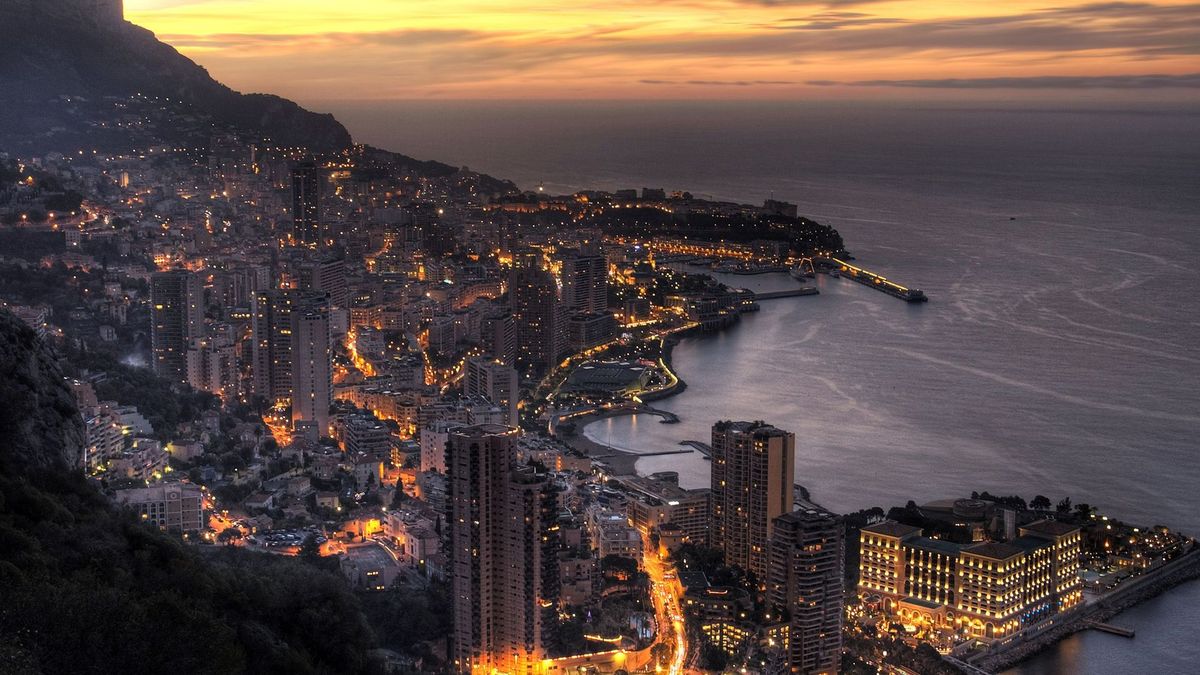 Night-time luxury retail district with high footfall and vehicle traffic